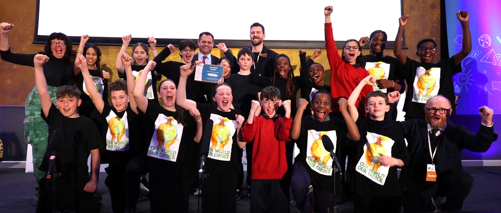 Our World Awards School of the Year winners 2026 on a stage cheering with Minister Richmond