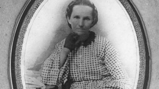 A very old black and white photo of a woman in an old fashioned blouse