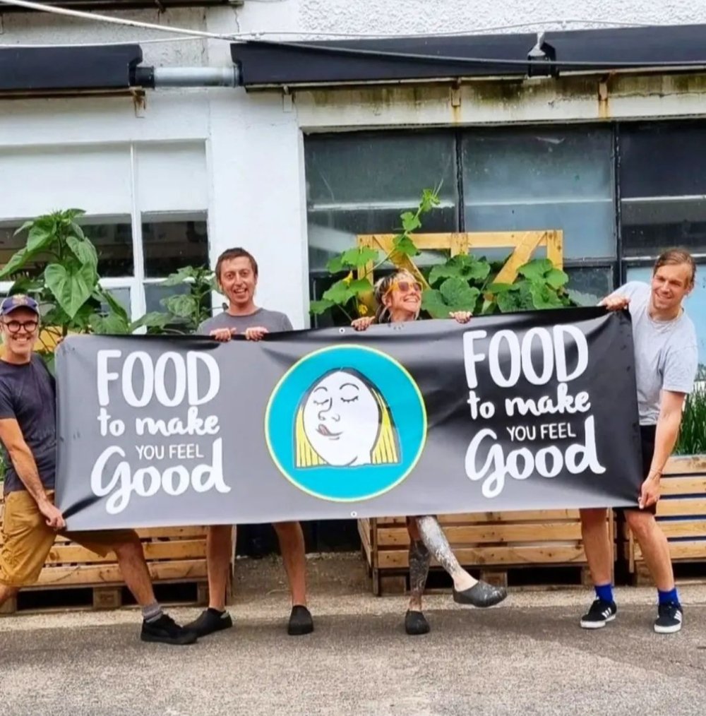 Group holding a banner reading 'Food to make you feel good'.