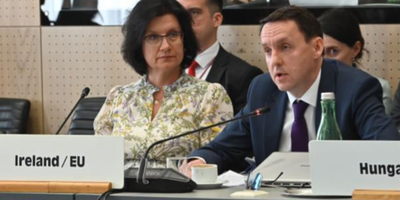 Man and woman speaking into microphones on a panel