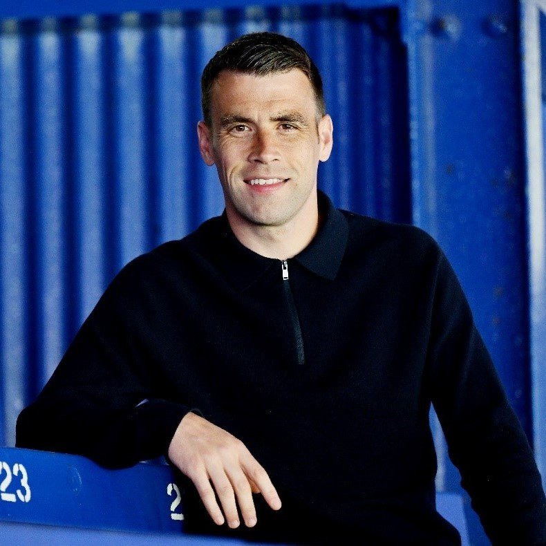 Man leaning on stalls in a football stadium