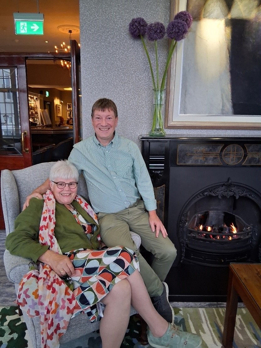 A couple sitting on a chair, smiling