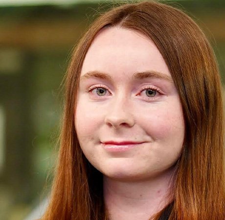 a young woman with long red hear smiling