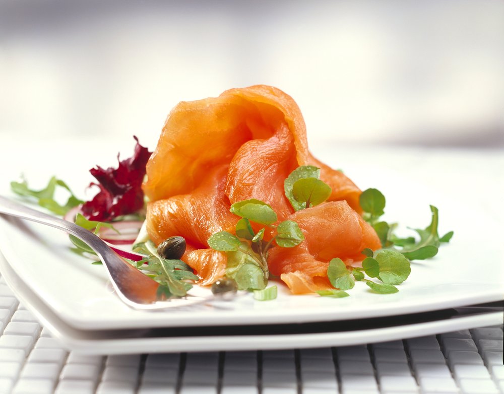 delicately placed smoked salmon on a white plate with cress
