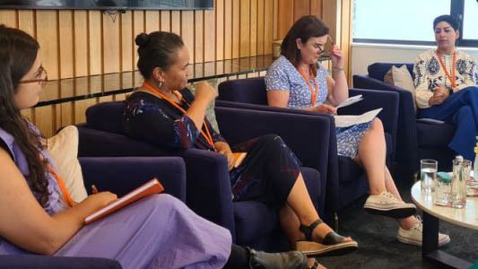 four women sitting on armchairs as panelists