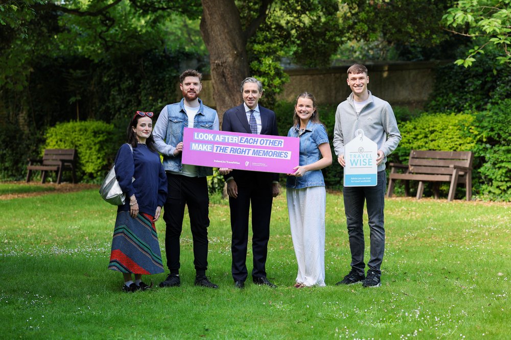 Tanaiste with four young people holding a make the right memories banner