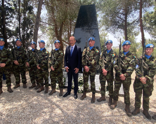 one man in a suit in a line with soldiers in their uniform