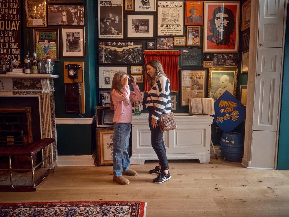Two women in the Little Museum of Dublin surrounded by framed Dublin paraphernalia