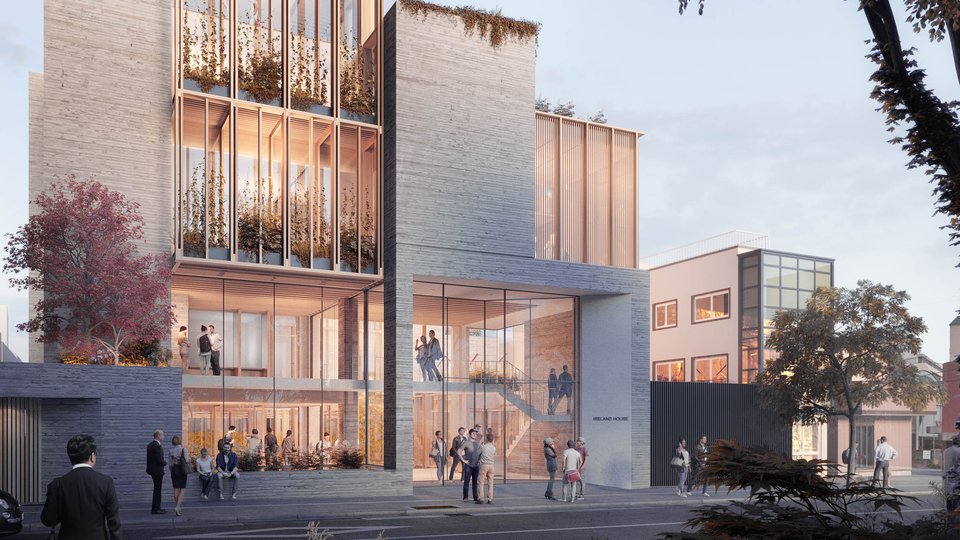 artist's impression of modern office block with lights on and a tree in the foreground