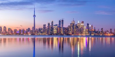 A view of Toronto's skyline, including the CN Tower, at sunset.