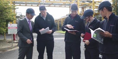 A group of men discussing documents.