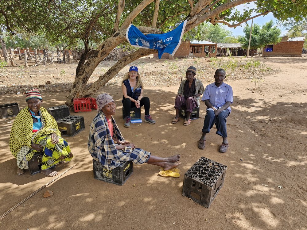 Triona sitting on a crate with some locals