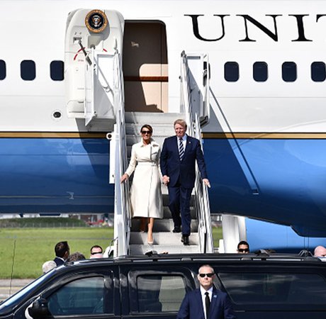 a woman and man coming down a staircase from an airplane