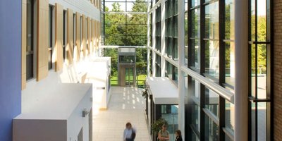 Corridor of a glass-walled university. The corridor stretches far into the background.