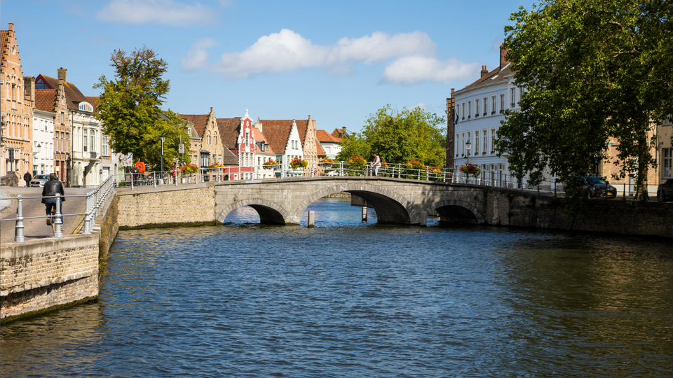 View down the river in Bruges with a bridge and medieval buildings in sight