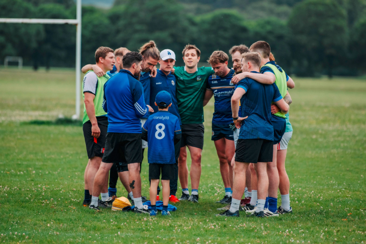 Men's team huddle with a young boy looking up at them