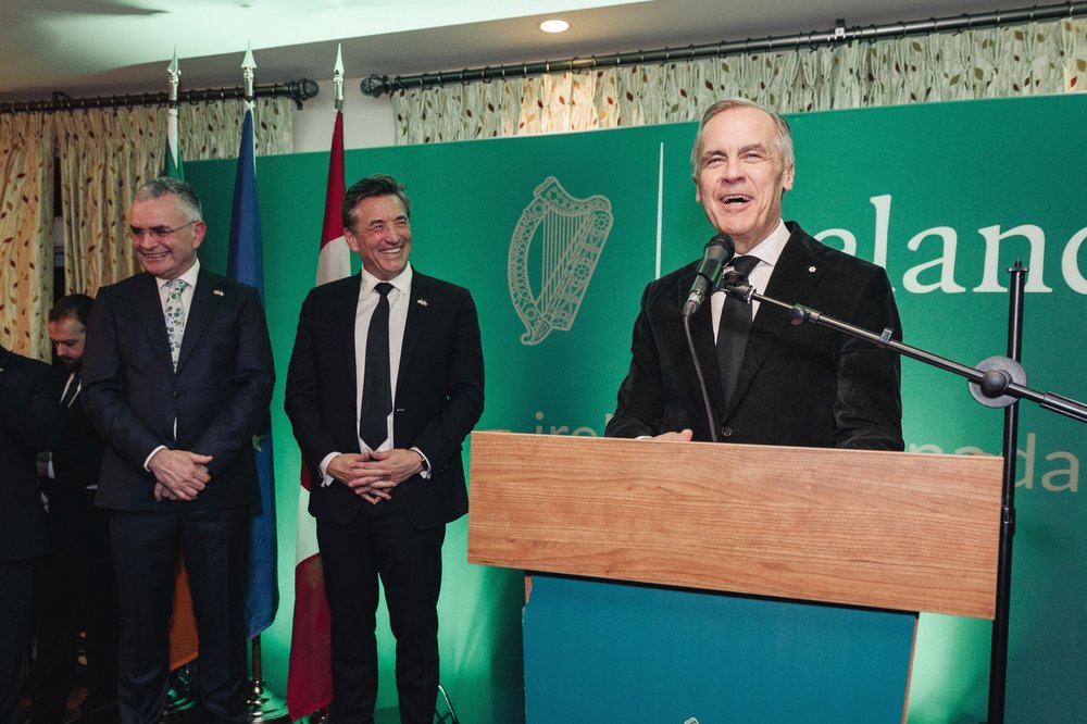 Canadian Prime Minister Mark Carney speaks at the Embassy's Saint Patrick's Day Event with Minister Dara Calleary and Ambassador John Concannon on the side in the background.