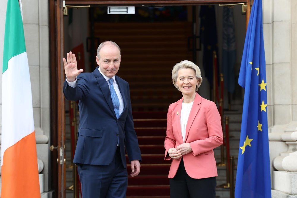 Micheal Martin and Ursula von der Leyen waving from the doorway of a building.