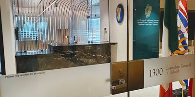 Reception desk of the Consulate viewed through the glass door to the office.