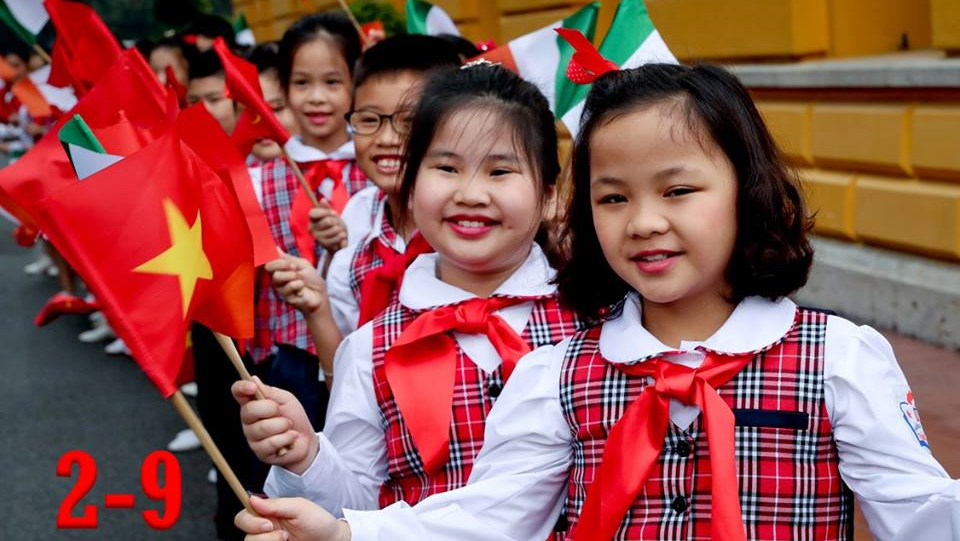 Vietnamese children wave Irish and Vietnamese flags