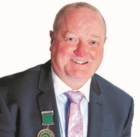 Vincent Jordan in a suit with a green medal