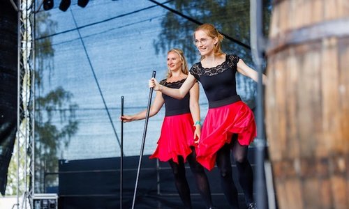 two girls in red and black outfits dancing with floor brushes