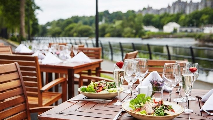 Salads on a cafe table overlooking a river.