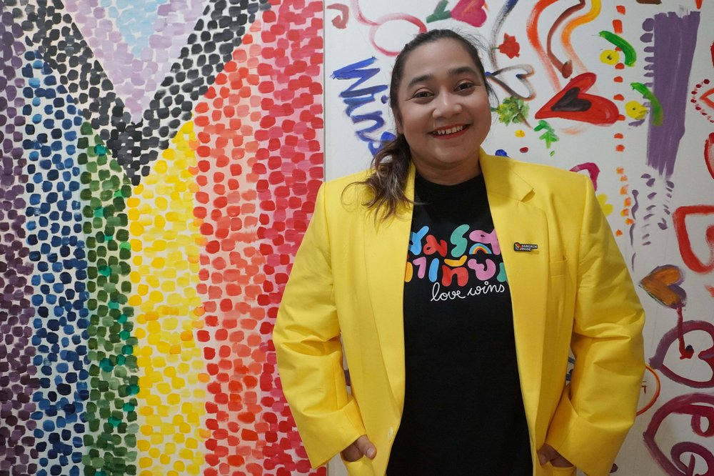 Woman standing in front of a pride flag