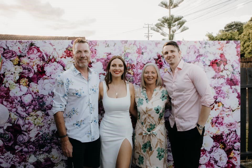 Group photo in front of a flower wall