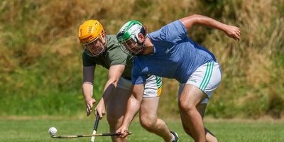 Two men tackling with sliotars and hurls