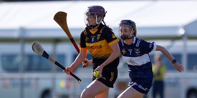 Two women running with hurls
