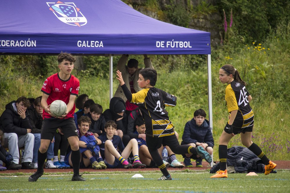boy on a pitch about to throw a ball in front of purple awning