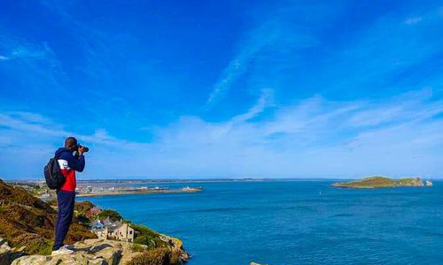 man sitting on the coast with a blue sky and sea