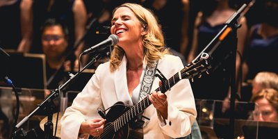 Aoife O'Donovan playing the guitar and singing