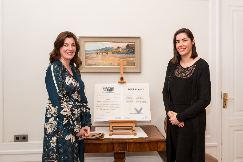 Two women standing infront of a painting