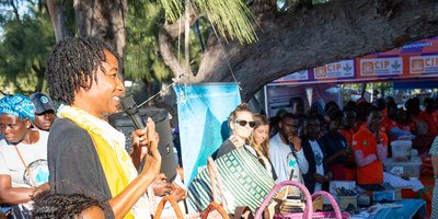 basket weaver at a stall speaking into a microphone