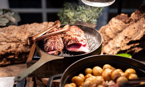 Beef and potatoes cooking on a skillet.