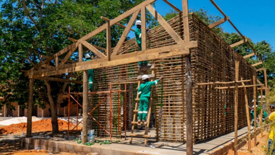 Participants of the Yopipila bioconstruction training on a  bio-constructed building that uses wood and bottles