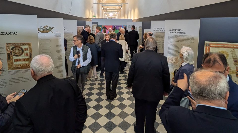 People looking at exhibition panels spaced along a corridor