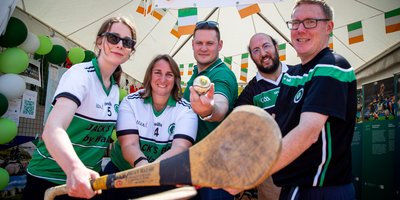 Five people holding a hurl smiling