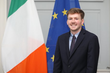 man standing in front of two flags