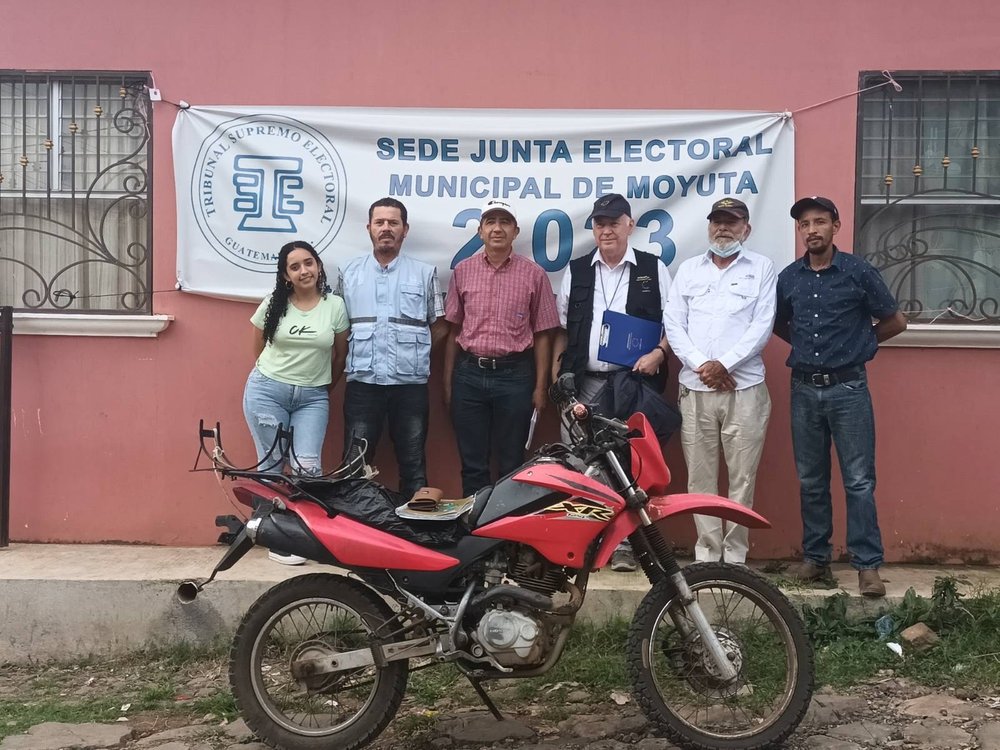 DORCHA IN GUATEMALA WITH MOYUTA JUNTA ELECTORAL, standing by a wall with a motorbike