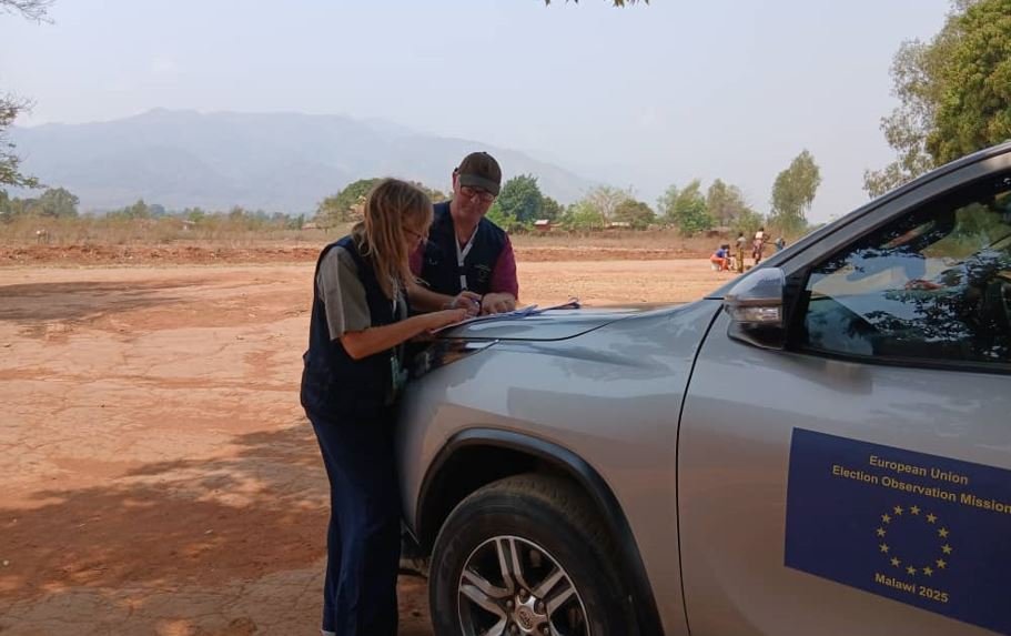 Duncan and his STO partner lean on a vehicle mapping their route for polling stations ahead of Election Day.