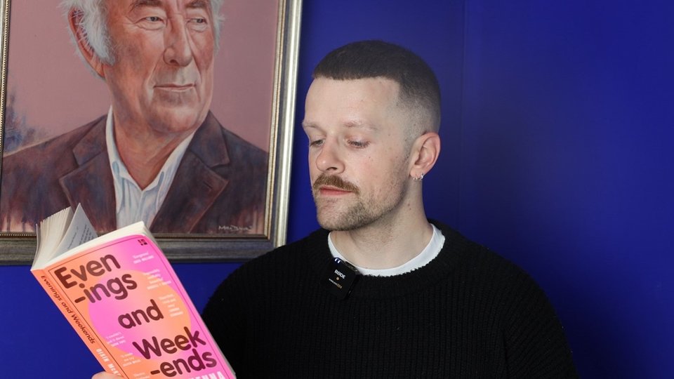 headshot of writer Oisín McKenna reading his book