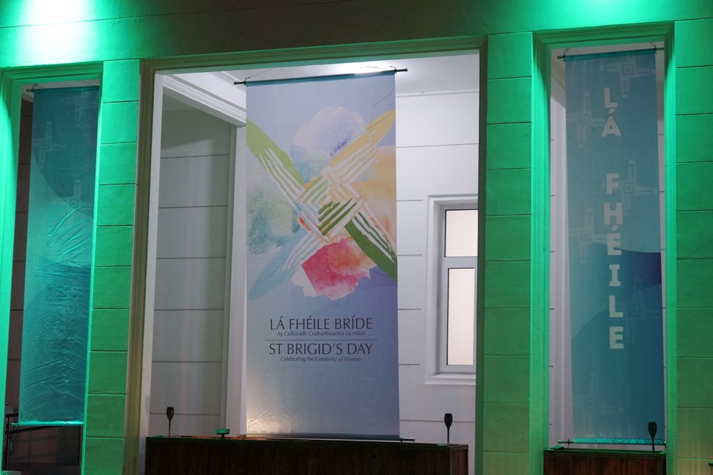 Building lit up green showcasing banner reading St Brigid's Day