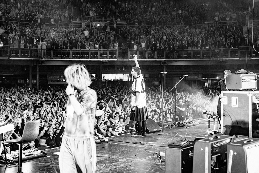 Black and white tour photo of Fontaines DC performing on stage