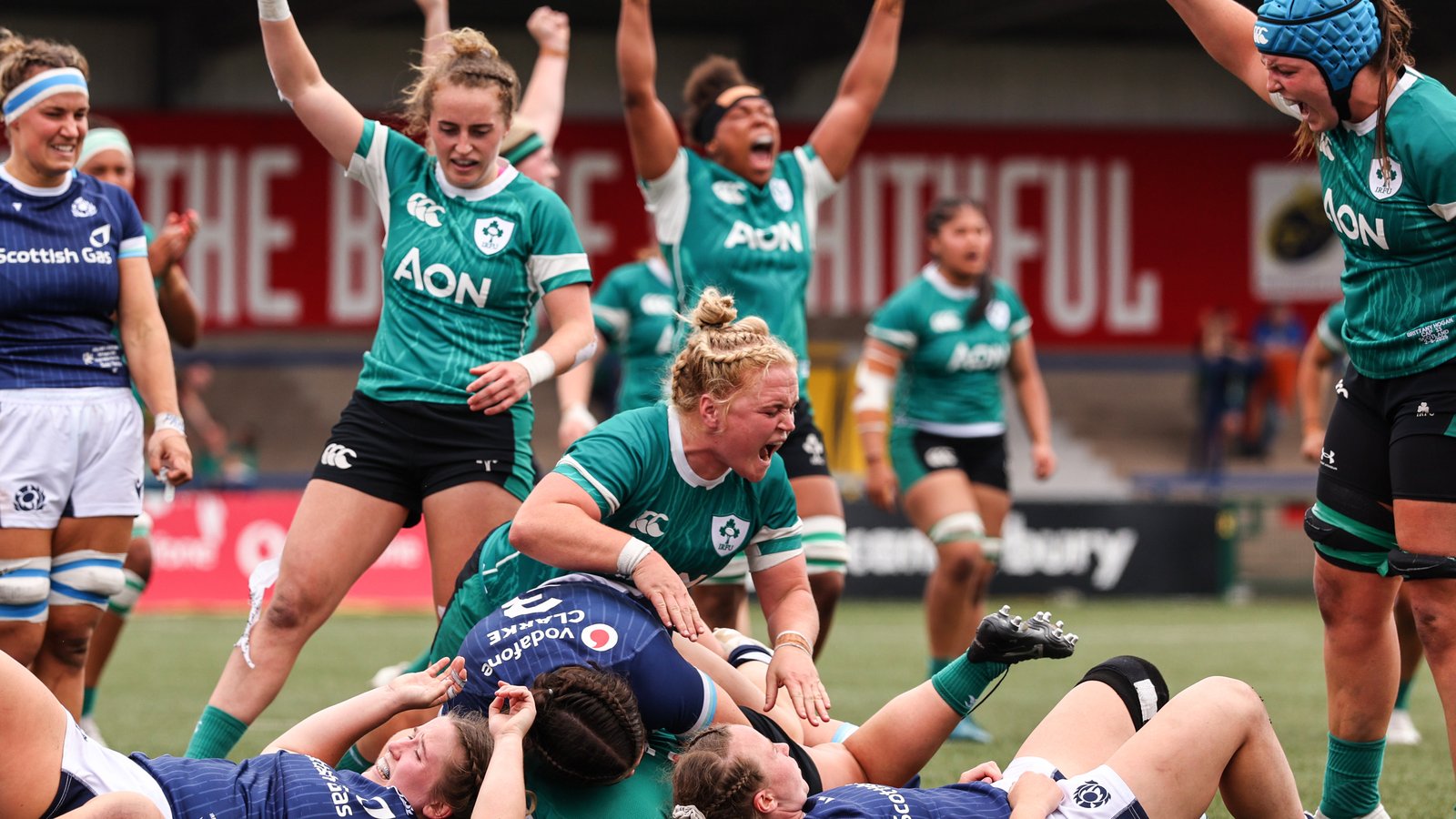 Irish women's rugby players celebrating on the pitch