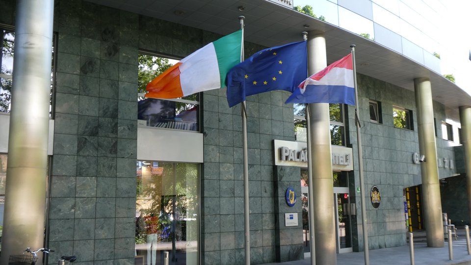 View of the exterior of the Embassy building with flags flying outside.