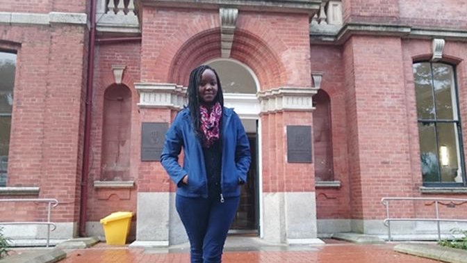 woman standing in front of an old red brick building