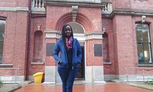 woman standing in front of an old red brick building